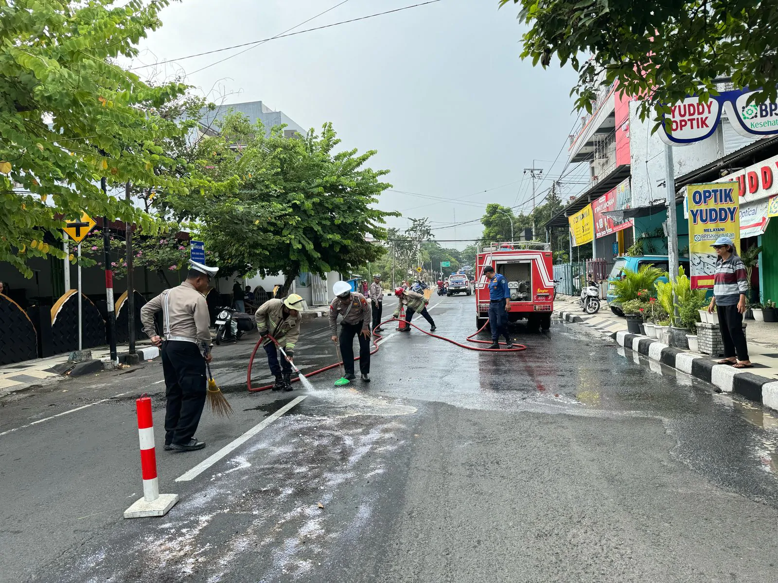 Sigap, Polisi bersama Damkar Bersihkan Tumpahan Solar di Jalan Raya Lamongan Antisipasi Kecelakaan